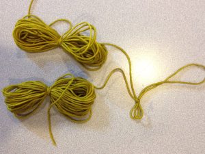 Find the two ends of the strand, and put them together in one hand.  Then pull along the joined strands with the other hand, until you reach the middle.  Tie a slip knot to mark the spot.  Then, wind one end into a yarn butterfly, and then the other.  You will have 2 yarn butterflies joined by the slip knot.  To knit, undo the slip knot and knit from the center of the strand.