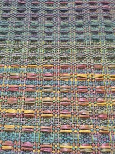 This is a waffle weave pattern for 4 shaft loom, from Davison book, page 57. I'm using stash yarn to play with colors and texture with the pattern. There is sock yarn - doubled - on top, some sparkly worsted in the middle, and the same worsted with ribbon on treadle rows 2 and 3 on the bottom. 